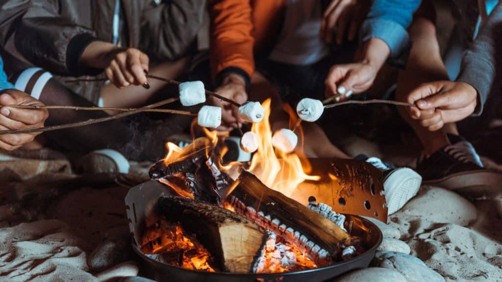 A family roasting marshmallows as a fall activity.