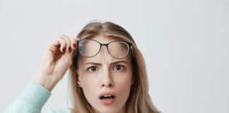 Surprised Young Female Model With Long Blonde Hair Wears Glasses