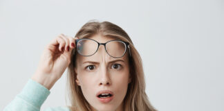 Surprised Young Female Model With Long Blonde Hair Wears Glasses