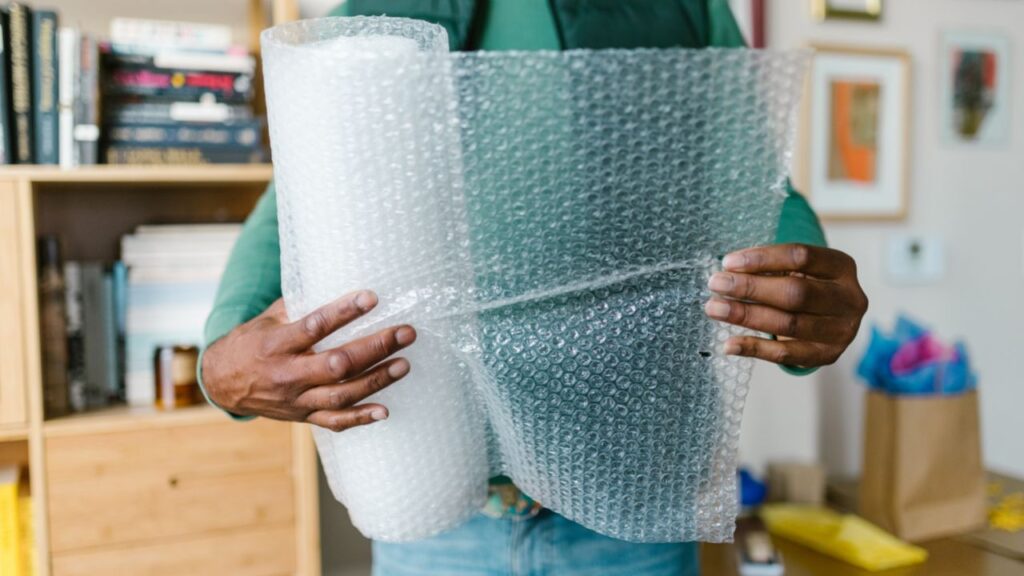 Photo of a person holding a roll of bubblewrap