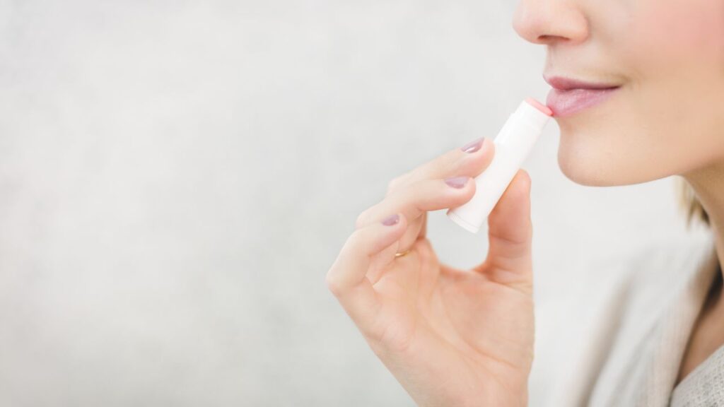 A woman applying chapstick