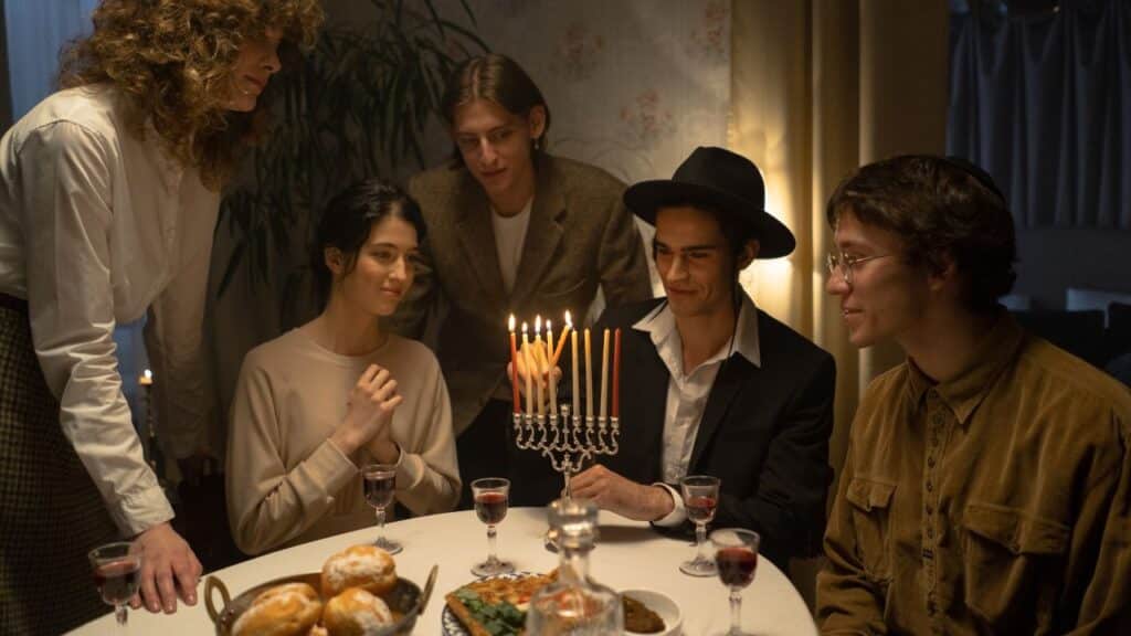 A group of friends lighting the menorah