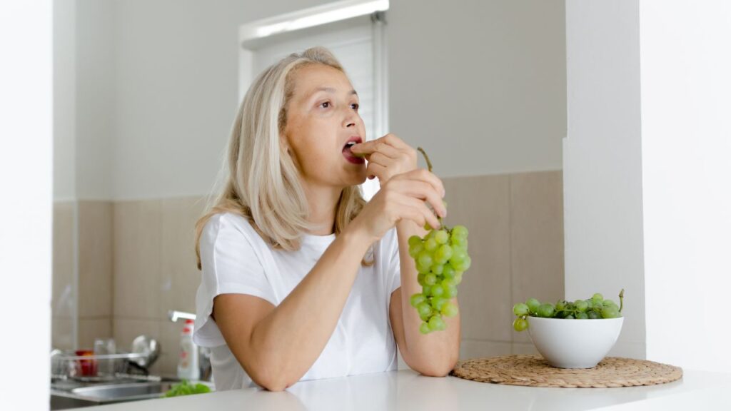 A person eating grapes.