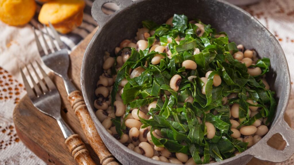 A photo showing a bowl of black eyed peas and collard greens